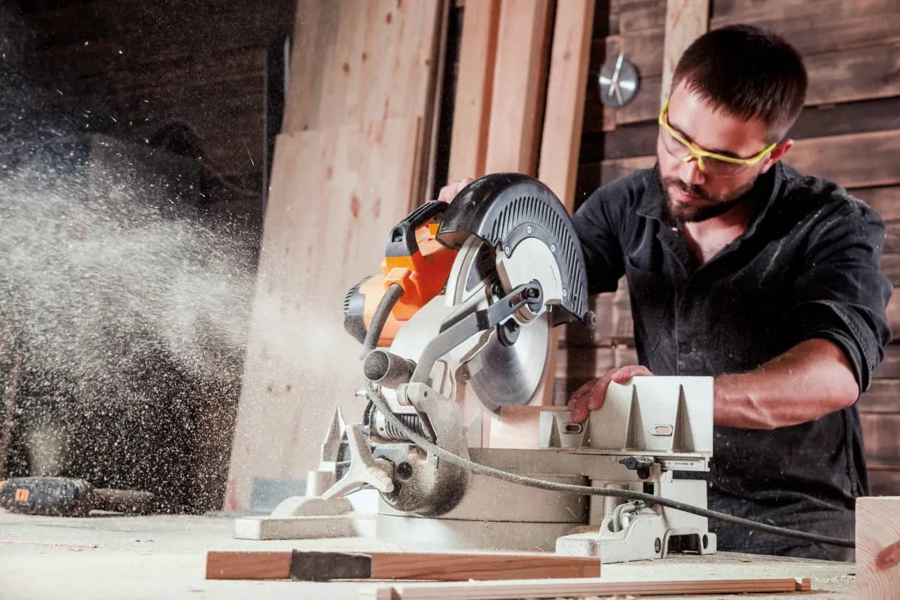 Man die hout zaagt met een afkortzaagmachine en CMT cirkelzaagblad